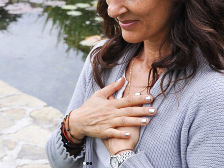Woman holding her hands to her chest.