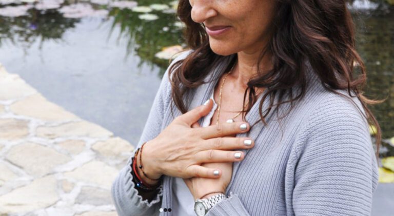 Woman holding her hands to her chest.