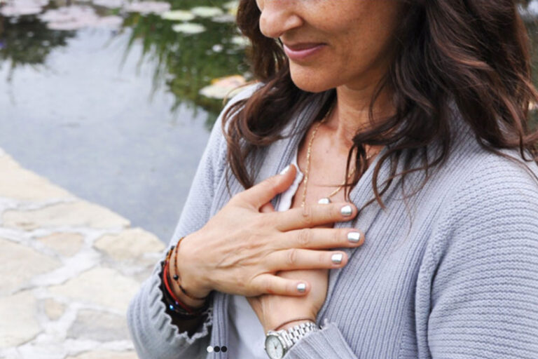 Woman holding her hands to her chest.