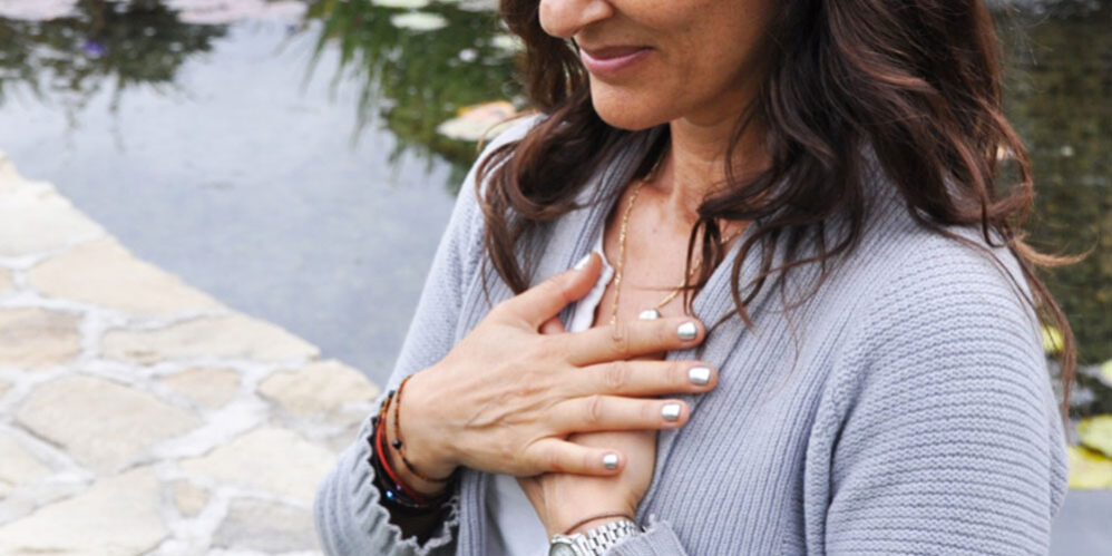 Woman holding her hands to her chest.